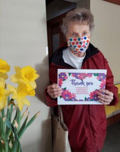 Elderly woman holding a thank you sign